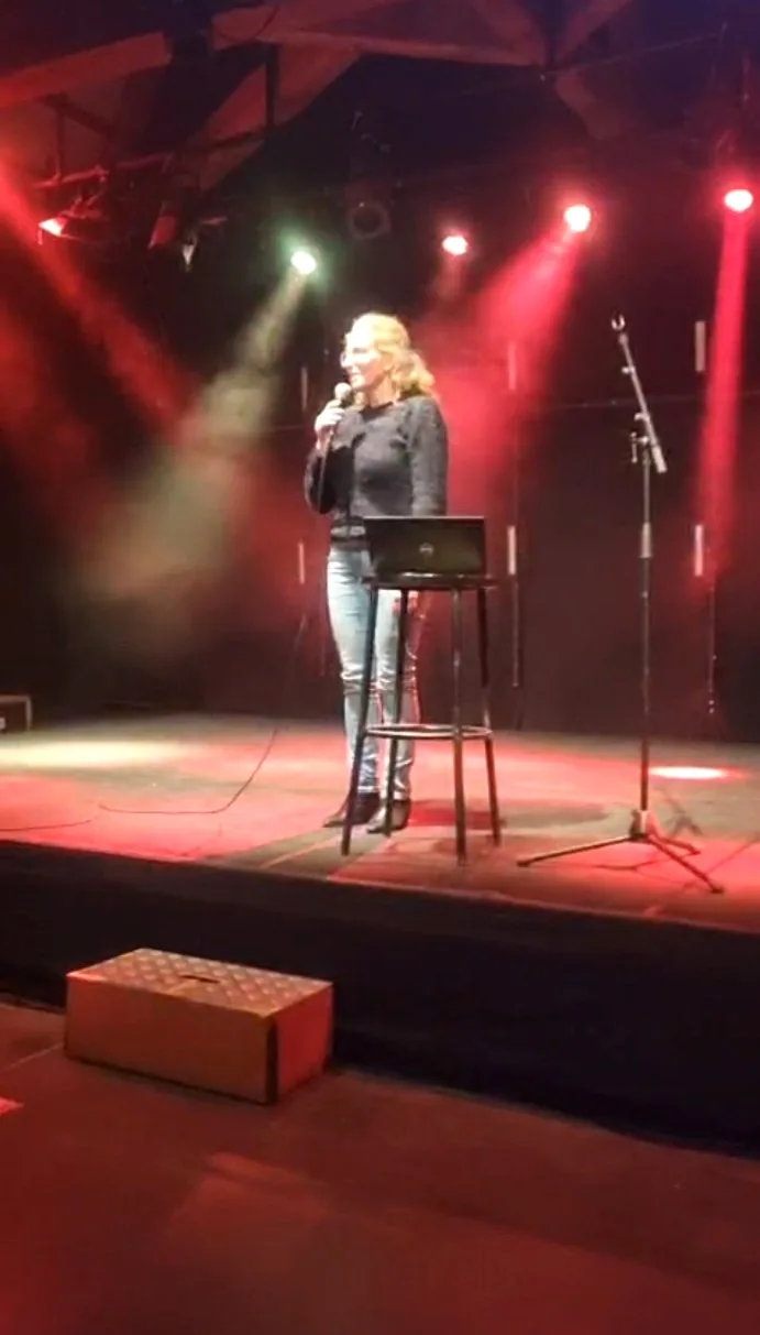 Valérie Beaumont sur scène lors d’une conférence, micro à la main